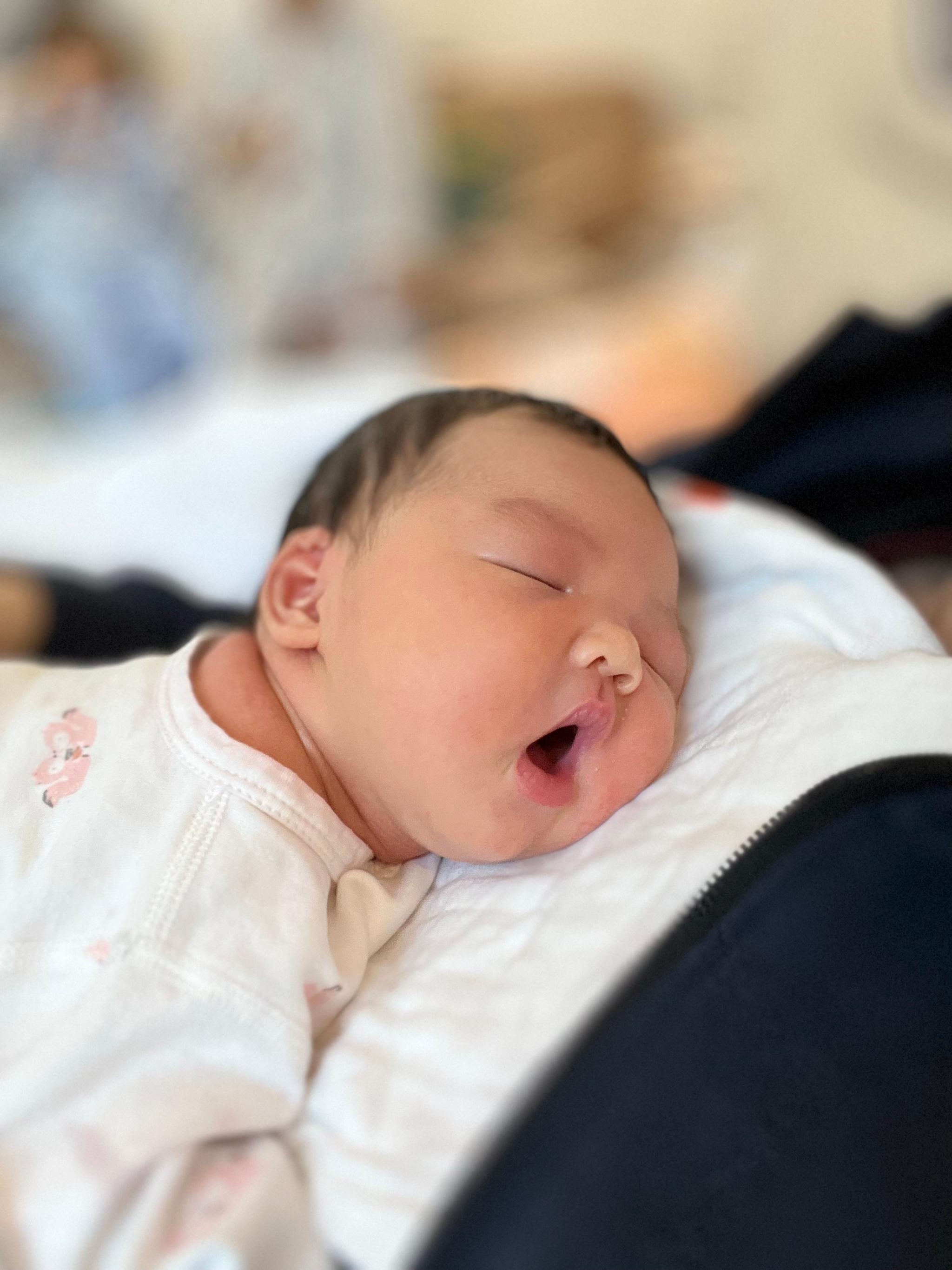 A newborn baby sleeping peacefully with a pacifier in its mouth